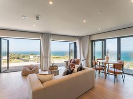 A living room with a sofa and table overlooking the ocean at tbc in St. Ives