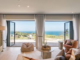 A living room with a coffee table and sofa overlooking the ocean at tbc St. Ives