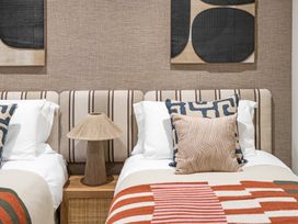 A bedroom with two beds and decorative pillows at tbc in St. Ives