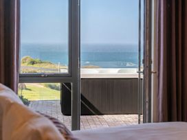 A bedroom with a view of the ocean and a spa at tbc St. Ives