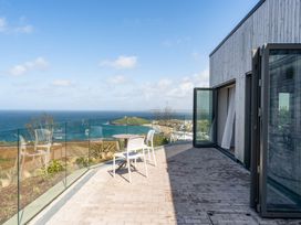 An outdoor area with a table and chair overlooking the sea at tbc St. Ives