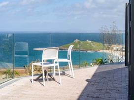 An outdoor patio with a table and chairs overlooking the sea at tbc in St. Ives