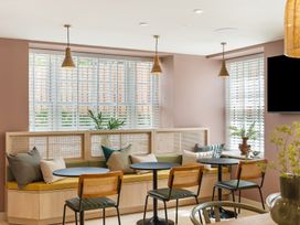 A dining room with seating and windows at Hidden 18- St Ives Bay Suite Hot Tub in St Ives