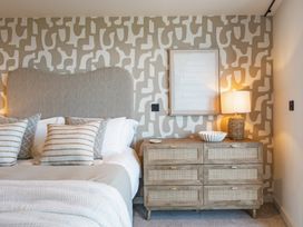 A bedroom with a bed and dresser at tbc in St. Ives