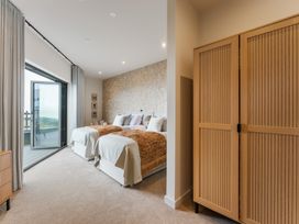 A bedroom with two beds and a wardrobe at tbc in St. Ives