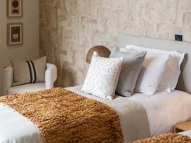 A bedroom with a bed and a chair at tbc St. Ives