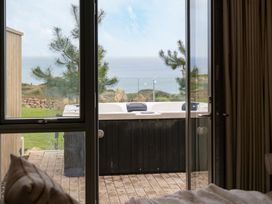 An outdoor area with a hot tub visible through a glass door at tbc in St. Ives