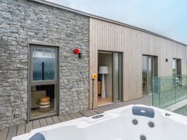 An outdoor patio with a hot tub and doors at tbc in St. Ives