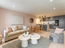 A living room with a sofa, armchair, and dining area at tbc in St. Ives