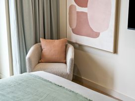 A bedroom with an armchair and wall art at tbc in St. Ives