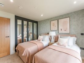 A bedroom with two beds and a bedside table at The Old Barn in St. Ives