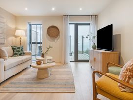A living room with sofa, coffee table and television at Hidden 19- Coastal Hot Tub, St Ives