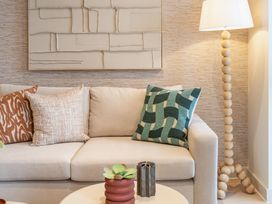 A living room with a sofa and lamp at Hidden 19- Coastal Hot Tub St Ives