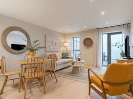 A living room with a sofa and dining table at Hidden 19- Coastal Hot Tub St Ives