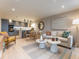 A living room with furniture and kitchen area at Hidden 19- Coastal Hot Tub St Ives