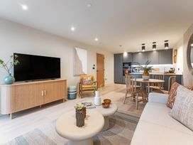 A living room with furniture and a kitchen area at Hidden 19- Coastal Hot Tub in St Ives