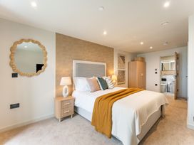 A bedroom with a bed and a wardrobe at Hidden 19- Coastal Hot Tub in St Ives