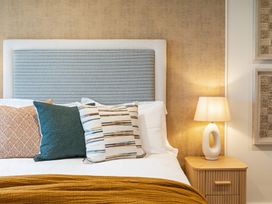 A bedroom with pillows and a lamp at Hidden 19- Coastal Hot Tub, St Ives