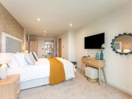 A bedroom with a bed and TV at Hidden 19- Coastal Hot Tub in St Ives