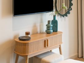 A living room with a sideboard and television at Hidden 19- Coastal Hot Tub in St Ives