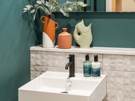 A sink with toiletries and decorative items at Hidden 19- Coastal Hot Tub, St Ives