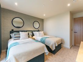 A bedroom with twin beds and mirrors at Hidden 19- Coastal Hot Tub in St Ives