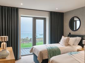 A bedroom with two beds and a sliding door at Hidden 19- Coastal Hot Tub in St Ives