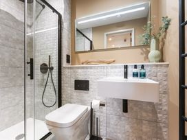A bathroom with a shower, toilet, and sink at Hidden 19- Coastal Hot Tub in St Ives