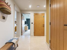 A hallway with doors and a bench at Hidden 19- Coastal Hot Tub in St Ives