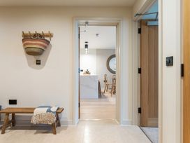 A hallway with a bench and a basket at Hidden 19- Coastal Hot Tub in St Ives