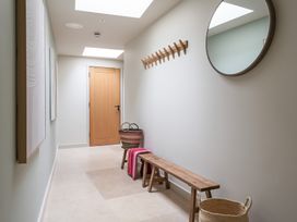 A hallway with a wooden door, mirror, and bench at tbc in St. Ives