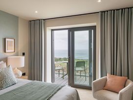 A bedroom with a bed and a door leading to a balcony at tbc St. Ives