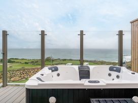 A hot tub with ocean view on a deck at tbc St. Ives