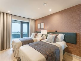 A bedroom with twin beds and a balcony door at tbc in St. Ives