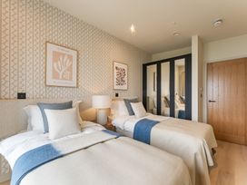 A bedroom with two beds and a wardrobe at tbc in St. Ives