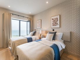 A bedroom with two beds and a window overlooking the sea at tbc St. Ives