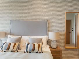 A bedroom with a bed and a mirror at tbc St. Ives