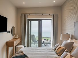 A bedroom with a bed and sliding door to a balcony at tbc St. Ives