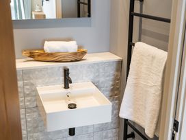 A bathroom with a sink and towels on a rack at tbc in St. Ives