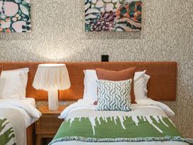 A bedroom with two beds, pillows, and a lamp at tbc in St. Ives