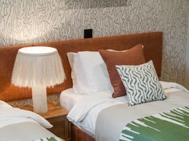 A bedroom with two beds and a lamp at tbc in St. Ives