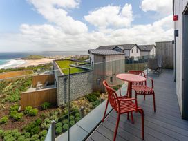 An outdoor area with a deck and chairs at Hidden 10- Godrevy View St Ives