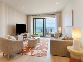 A living room with a sofa and television at Hidden 10- Godrevy View St Ives