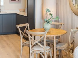 A dining room with a wooden table and chairs at Hidden 10- Godrevy View in St Ives