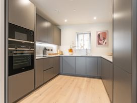 A kitchen with an oven, microwave, and kitchen cabinets at Hidden 10- Godrevy View in St Ives