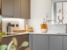 A kitchen with modern cabinets and a vase on the countertop at Hidden 10- Godrevy View St Ives