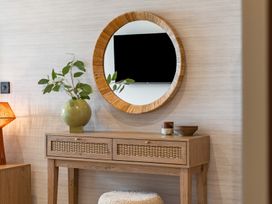 A table with a mirror and plant in the living room at Hidden 10- Godrevy View, St Ives