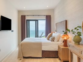 A bedroom with bed and television at Hidden 10- Godrevy View in St Ives