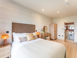 A bedroom with a bed and wardrobe at Hidden 10- Godrevy View in St Ives