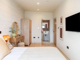 A bedroom with a bed and wardrobe at Hidden 10- Godrevy View in St Ives